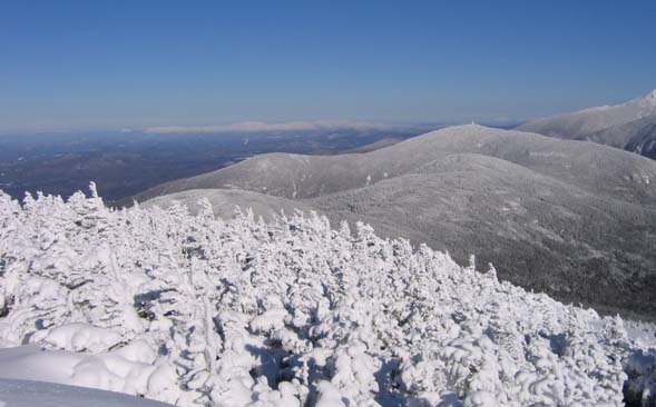 View of Kinsman Ridge and Cannon Mountain with the snow-covered Presidentials on the horizon (photo by Mark Malnati)