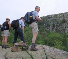 Donna, Tom, and Dennis peering over the edge of a cliff (photo by Mark Malnati)