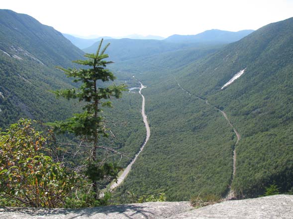 The view from Mount Willard's ledges showing the U-shape of Crawford Notch.  That's Route 302 running through the center and the railroad tracks are to the right of the road. (photo by Karl Searl)